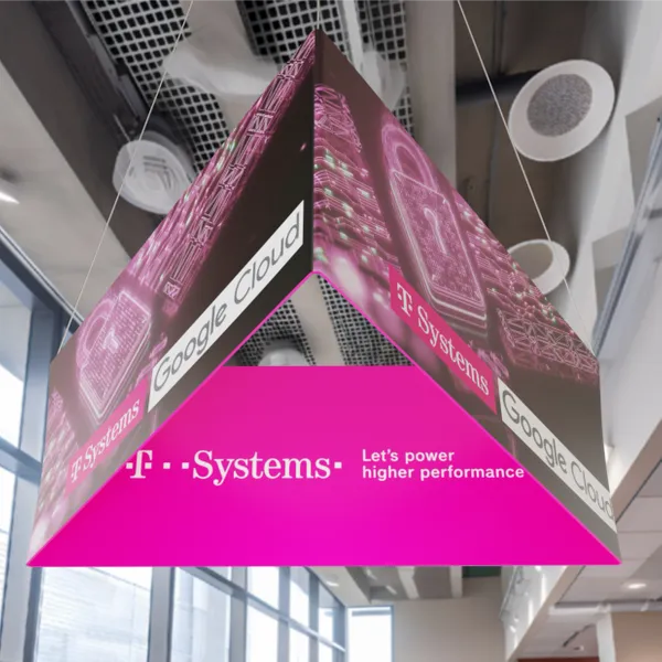 An inverted pyramid structure hangs from a ceiling, displaying New Balance logos, inside a building with exposed wooden beams and stairs in the background.